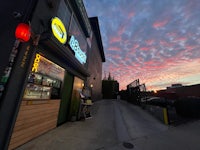 a restaurant with a sign on it at sunset