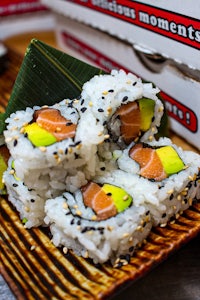 a plate of sushi on a table next to a box