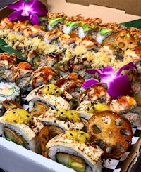 a box of sushi in a box with a flower on top