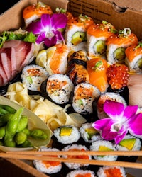 a box of sushi with chopsticks in it