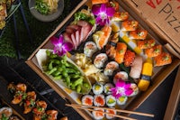 japanese food in a box with chopsticks and sushi