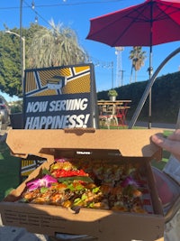 a person holding a pizza in a box